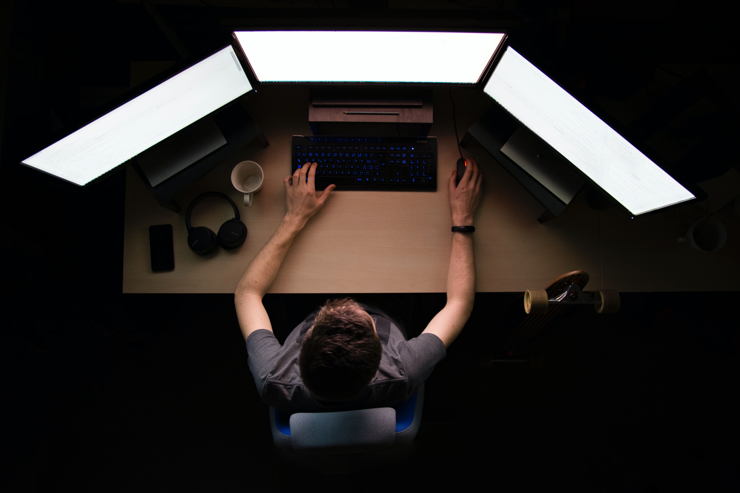 Programmer using three monitors to learn coding